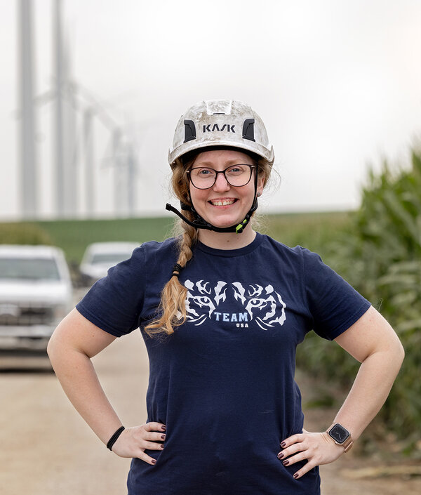 A female service technician for wind turbines standing outside