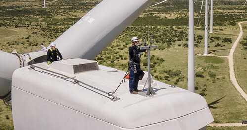 Service technician standing on a wind turbine onshore
